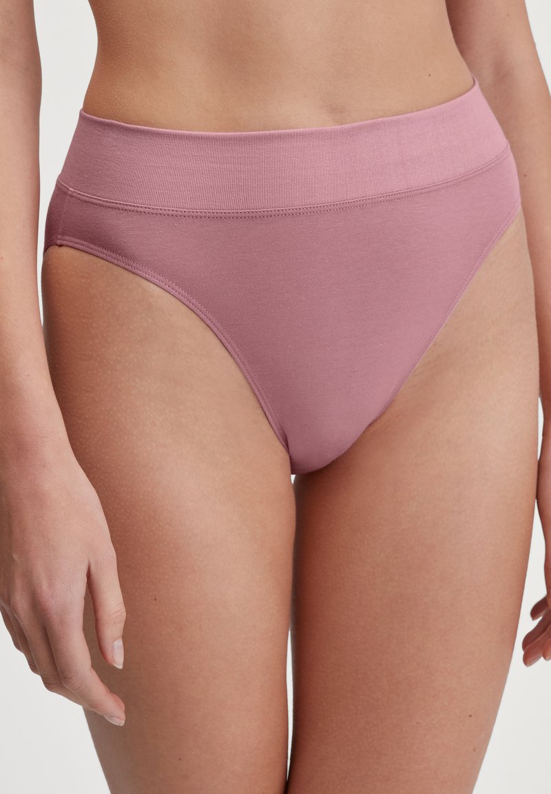 Culotte taille haute en coton rose clair avec une texture lisse, une large ceinture et des détails de couture minimaux.