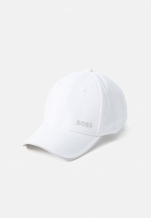 Valge puuvillane pesapallikeep, millel on ümar kõrgus, kerge tekstuur ja kõver ääre. Esiküljel on hõbedane "BOSS" logo.