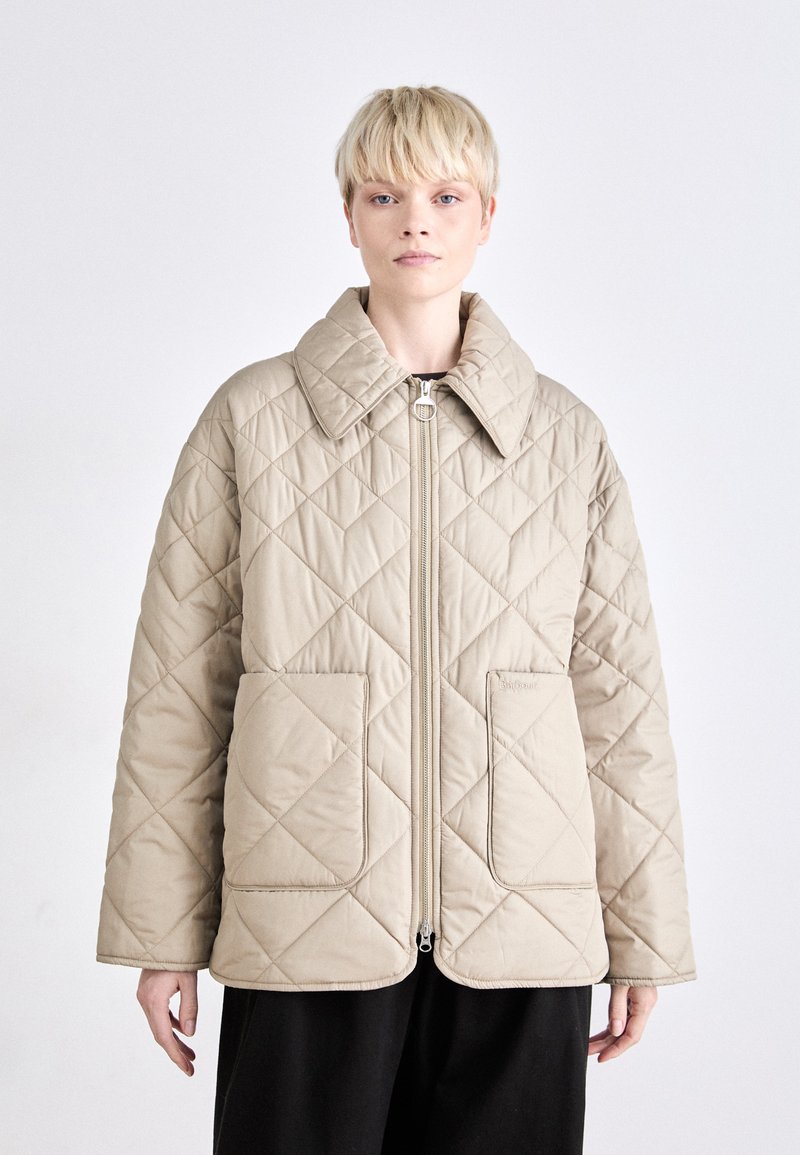 Beige gesteppte Jacke mit breitem Kragen, Reißverschluss vorne und zwei großen Fronttaschen. Das Rautenmuster auf dem Stoff verleiht Textur.