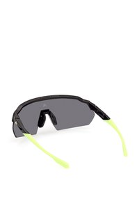 Sportiga solglasögon med en svart ram, grå linser och ljusgröna gummihuvuden. Vinklad design, lätt material och texturerade accenter.
