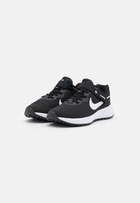 Chaussures de sport noires avec une tige en maille, un logo blanc, une semelle noire texturée et un col rembourré. Comprend des lacets et une sangle pour un maintien sécurisé.