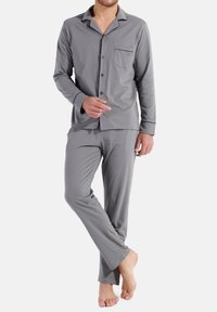 Grijs pyjama set met lange mouwen en broek, gemaakt van zachte stof. Heeft een kraag, knopen en een borstzak. Soepele textuur.