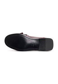 Sola di scarpa in pelle con forma piatta e leggermente arrotondata. Presenta una finitura nera liscia, cuciture lungo i bordi e dettagli di marca.