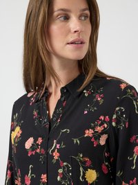 Črna srajca s kratkimi rokavi in cvetličnim vzorcem v roza, rumeni in zeleni barvi. Mehka tkanina s klasičnim ovratnikom in dolgimi rokavi.