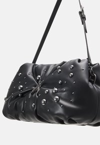 Borsa a mano in pelle nera con un design arricciato, decorata con vari borchie metalliche e una finitura liscia. Inclusa una tracolla regolabile.