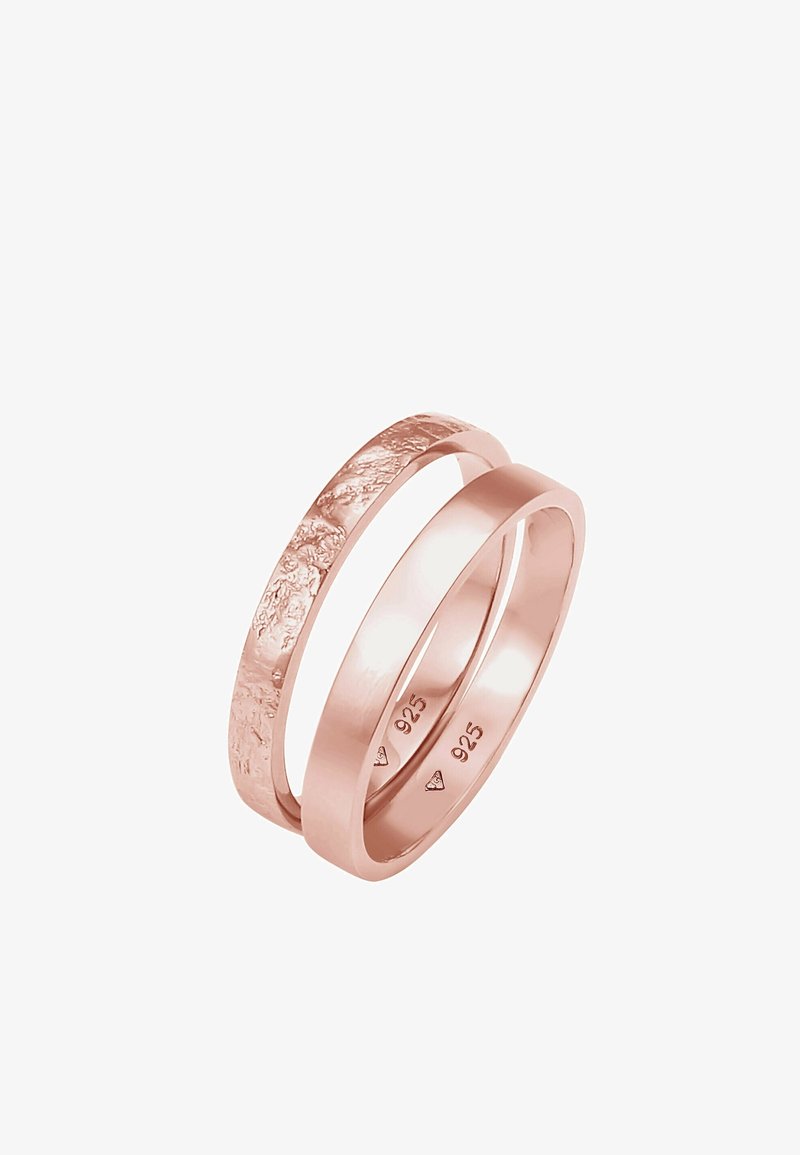 Deux bagues entrelacées en or rose, l’une avec une finition lisse et l’autre avec une surface texturée, toutes deux estampillées "925".