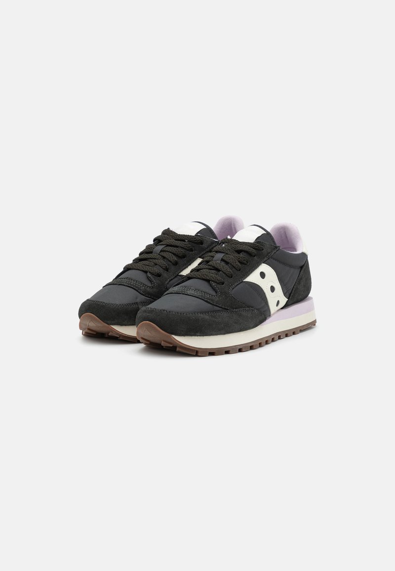 Schwarze Wildleder- und Nylon-Sneaker mit lila Akzenten, weißem Logo, Schnürdesign und brauner Gummisohle. Leicht und strukturiert.
