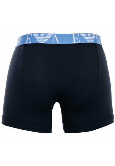 Marineblaue Baumwollboxershorts mit einem hellblauen elastischen Bund, der ein Logo und Schriftzüge zeigt. Glatte Textur und taillierte Passform.