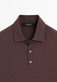 Bordeaux polo shirt med flad krave, tre sølvknapper og en blød tekstur. Etiket læser "Massimo Dutti," hvilket angiver mærket.