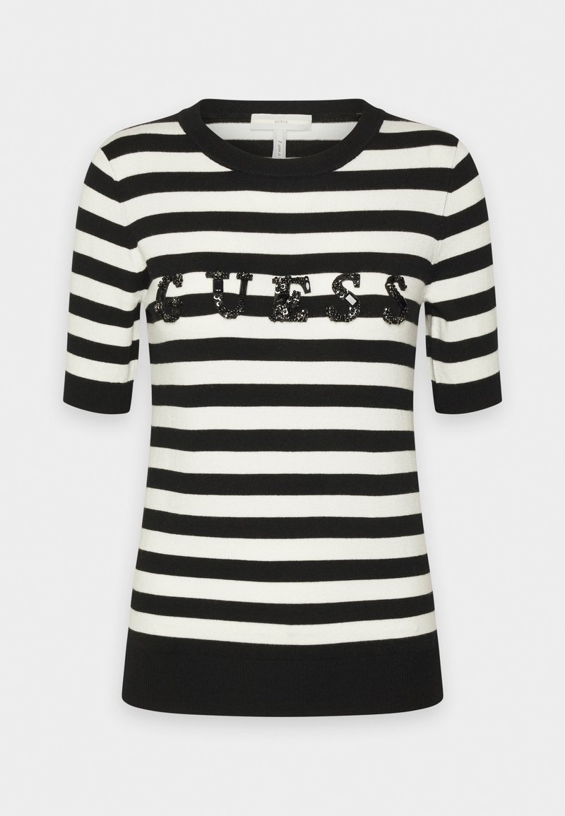 Top manches courtes rayé horizontalement noir et blanc, col rond et logo « GUESS » en sequins noirs sur la poitrine.
