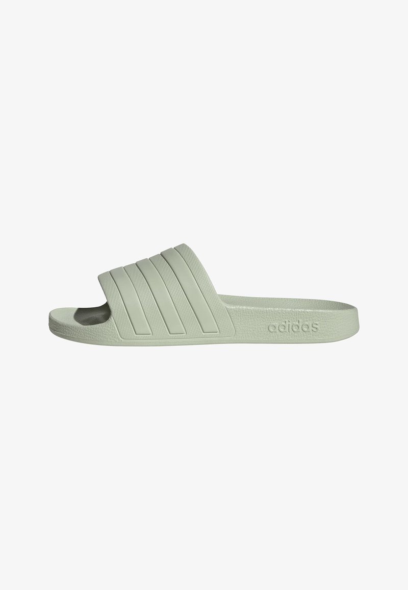 Sandale slide Adidas vert clair avec trois rainures sur la bride et une semelle texturée, vue latérale montrant le logo de la marque embossé.