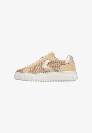 Low-top sneaker with beige woven fabric, suede accents, metallic logo detail, white laces, and a thick white ridged sole.