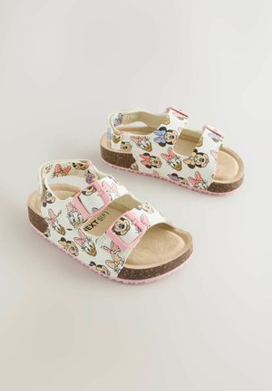 Fehér szandálok színes rajzfilmfigurás mintákkal, két rózsaszín állítható pánttal, barna talpbéléssel és texturált rózsaszín gumitalppal.