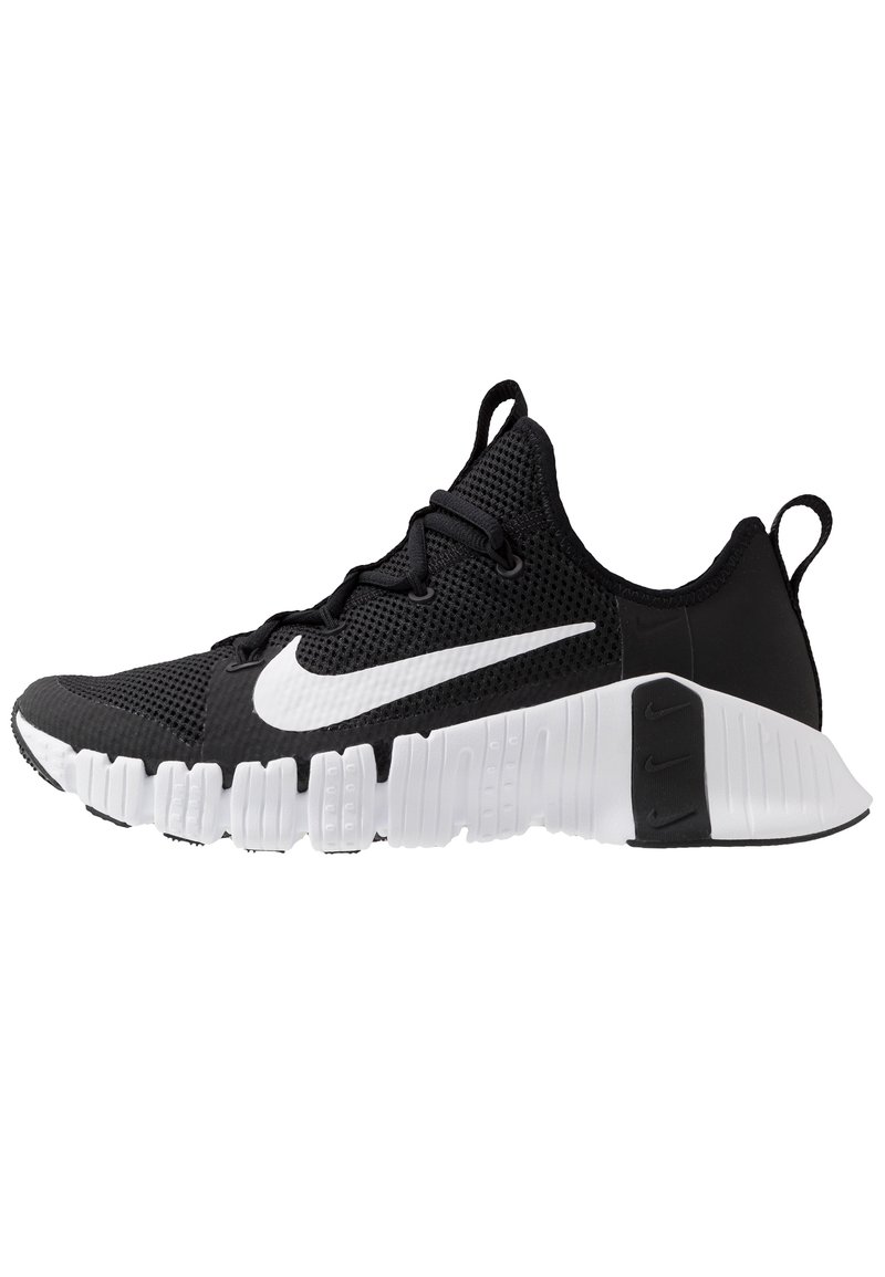 Sort og hvid Nike træningssko med åndbart mesh-øvre, hvid sål med dybe riller og stort hvidt Nike swoosh på siden.