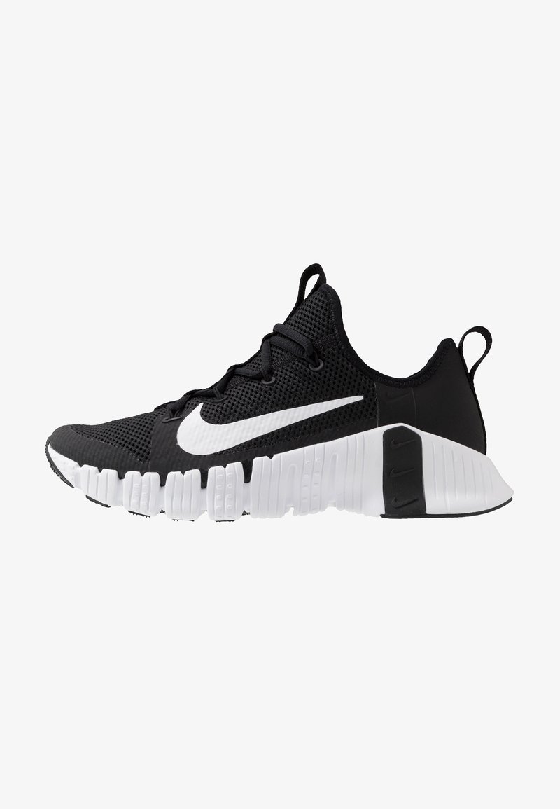 Sort og hvid Nike træningssko med åndbart mesh-øvre, hvid sål med dybe riller og stort hvidt Nike swoosh på siden.
