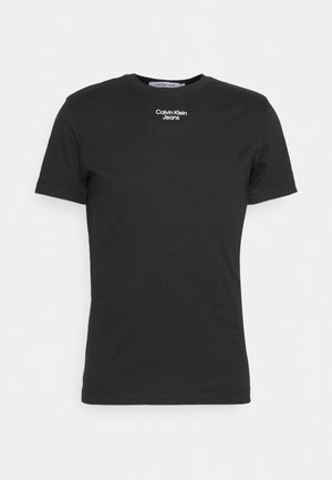 Schwarzes T-Shirt mit kurzen Ärmeln und Rundhalsausschnitt mit kleinem weißen "Calvin Klein Jeans"-Logo, mittig nahe dem Kragen platziert.