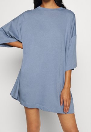 Übergroßes blaues T-Shirt aus weicher Baumwolle mit Rundhalsausschnitt, abgesenkten Schultern und kurzen Ärmeln, mit lockerem Schnitt und seitlichen Schlitzen.