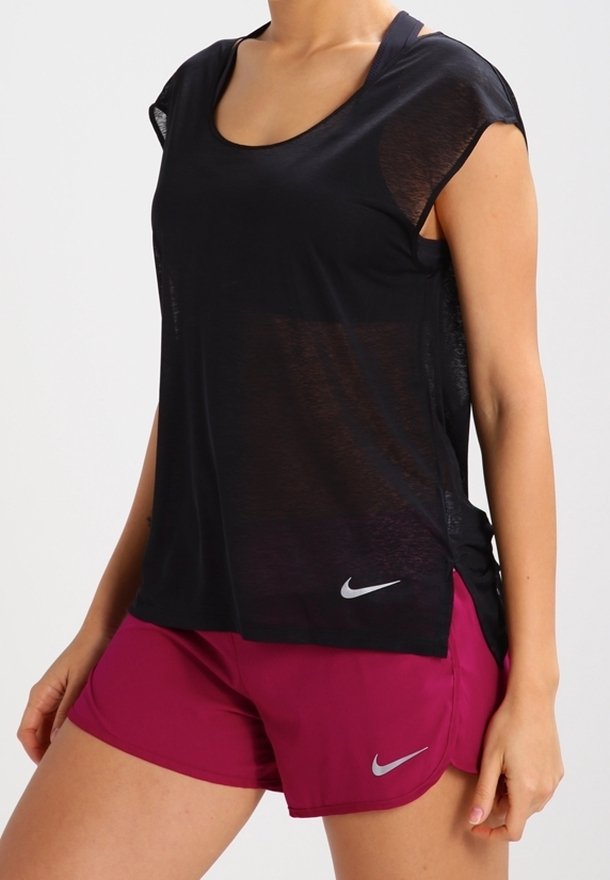 Mustat, lyhythihaiset urheilupaidat, joissa on pyöreä kaula-aukko ja läpikuultava pinta. Yhdistetty vaaleanpunaisiin shortsien, joissa on hopeinen Nike-logo helma.