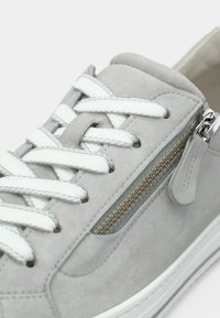 Γκρι σουέντ αθλητικό παπούτσι με λευκά κορδόνια και φερμουάρ στο πλάι. Διαθέτει ομαλή υφή και λευκή σόλα από καουτσούκ με αντίθετη διακοσμητική γραμμή.