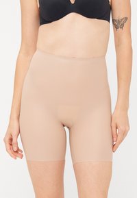 Beige formende shorts med høyt liv, jevn tekstur og midt-lår lengde. Har en diskret åpning i midten.