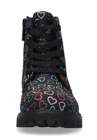 Schwarze Knöchelstiefel mit Herzmustern in mehreren Farben. Sie verfügen über eine glatte, glitzernde Oberfläche, ein Schnürdesign und eine Gummisohle.