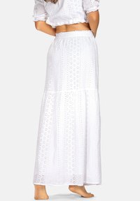Biała maxi spódnica wykonana z haftowanej bawełny; posiada wzór dziurkowany oraz warstwowy fason z elastycznym pasem.