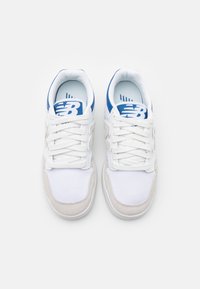 Sneakers med övre del i vitt mesh, grå mockadetaljer, blå detaljer och vita snören. Anmärkningsvärt New Balance-logotyp på tungan.