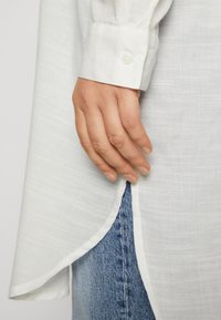 ONLY Carmakoma CARAPELDOORN SOLID V NECK SHIRT - Palaidinė - cloud dancer