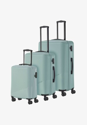 Three mint-green suitcases of varying sizes feature a textured ribbed design, black handles, and four black wheels for easy maneuverability.