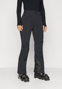 Svarta skidbyxor med en åtsittande design, som har en dragkedjeficka, knappstängning och kontrasterande mörkgrå detaljer vid nederkant av benen.