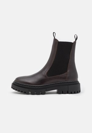Bottines en cuir marron avec panneaux latéraux élastiques, bout arrondi, semelle en caoutchouc noir robuste et languettes pour un enfilage facile.