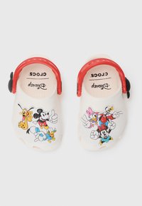 Witte Crocs met rode bandjes en prints van Disney-personages, waaronder Mickey, Minnie, Donald, Daisy en Pluto. Lichtgewicht, met een gestructureerd ontwerp.