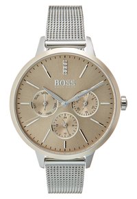 Reloj de pulsera de malla plateada con una esfera texturizada de tono dorado. Cuenta con tres subesferas, marcadores de hora plateados y un acento de cristal a las 12 en punto.