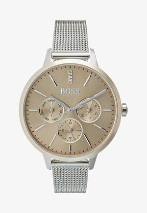 Silver mesharmbandsur med en texturerad guldtonad urtavla. Har tre subdials, silverfärgade timmarkörer och en kristallaccent vid klockan 12.