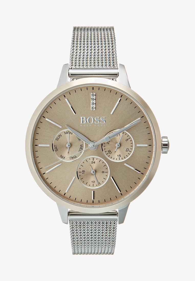 Srebrna mrežasta zapestnica s teksturirano zlato-tonirano površino. Ima tri poddialke, srebrne kazalce za ure in kristalni poudarek ob 12. uri.