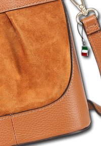 Bruine suède en leren handtas met een ronde vorm, voorzien van een metalen hardware-detail en een klein Italiaans vlaggetje charm.