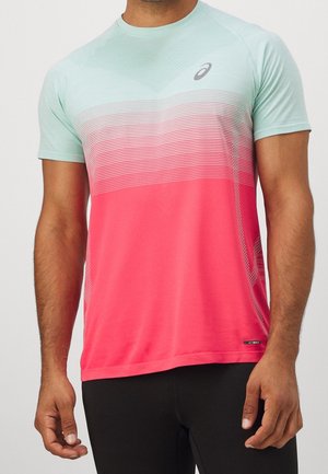 Mężczyzna w sportowej koszulce z krótkim rękawem, z jasnorozieloną górą, czerwonym dołem, białymi poziomymi liniami i logo ASICS na piersi.