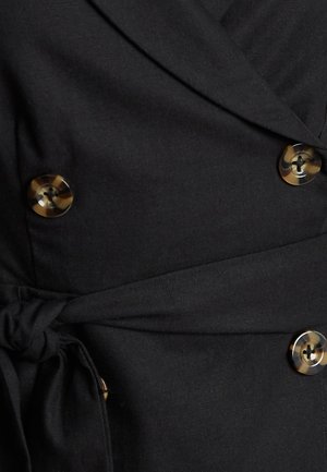 Zwarte wikkeljurk met een gestrikte taille en grote ronde knopen met een tortoisepatroon. De stof lijkt glad met een lichte glans.