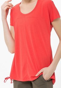 Camiseta de manga corta y cuello redondo en un brillante color coral, fabricada con un suave tejido con sutil textura y detalles de cordón en los laterales.