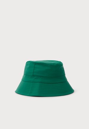 Sombrero de pescador verde con ala ancha y filas de pespuntes, sobre un fondo liso y claro.