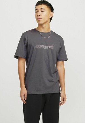 Grå bomulds T-shirt med korte ærmer, med en grafik i lyserød, der står "CORE DEPT" på tværs af brystet. Flad, rund hals.