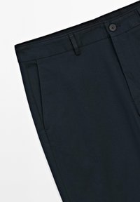 Pantalons bleu marine foncé avec une finition lisse, dotés de poches avant et d'un bouton unique à la taille.