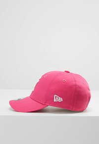 Casquette de baseball rose en coton, avec une visière incurvée, un logo brodé en blanc à l'avant et des trous d'aération sur les côtés.
