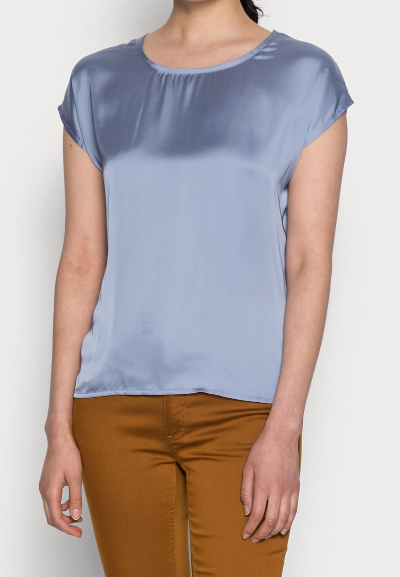 Blusa azzurra chiara a maniche corte in tessuto morbido con scollatura rotonda e vestibilità rilassata. Adatta per un abbigliamento casual.