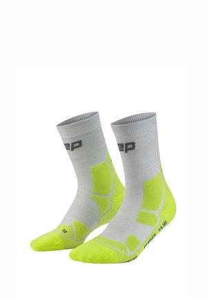 Hellgraue und neongelbe Sportsocken mit Polsterzonen und einem Logo nahe der Bündchen- und Sohlenpartie.