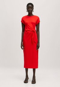RotesMidi-Kleid aus einem weichen Stoff, mit rundem Ausschnitt, kurzen Ärmeln und einem seitlichen Bindedetail. Glatte Textur und gerader Schnitt.