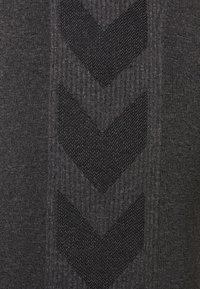 Maglione grigio scuro con un motivo in maglia testurizzato e design a zigzag neri in rilievo. Tessuto liscio con dettagli a costine per un contrasto.