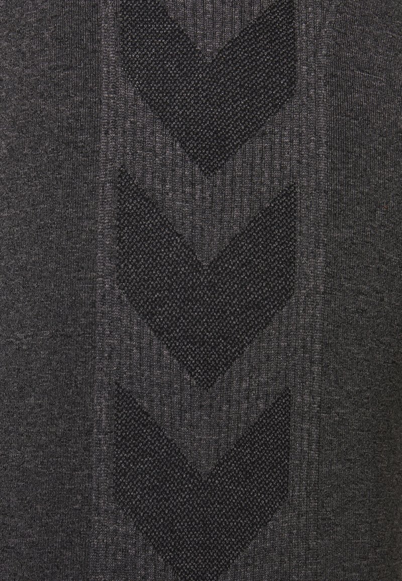 Suéter gris oscuro con un patrón de punto texturizado y diseños de chevron negros en relieve. Tejido suave con acentos acanalados para crear contraste.