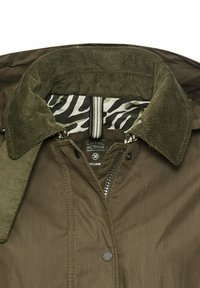 Oliwkowa kurtka z kołnierzem z kordurowej tkaniny, z podszewką w zebrę i zapięciem na zamek błyskawiczny. Metka oznacza "camel active", rozmiar 36.