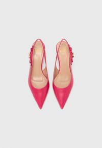Rózsaszín bőr slingback magassarkú cipők hegyes orral, arany kiegészítőkkel és oldalsó masnival. Sima textúrájú, elegáns dizájn.